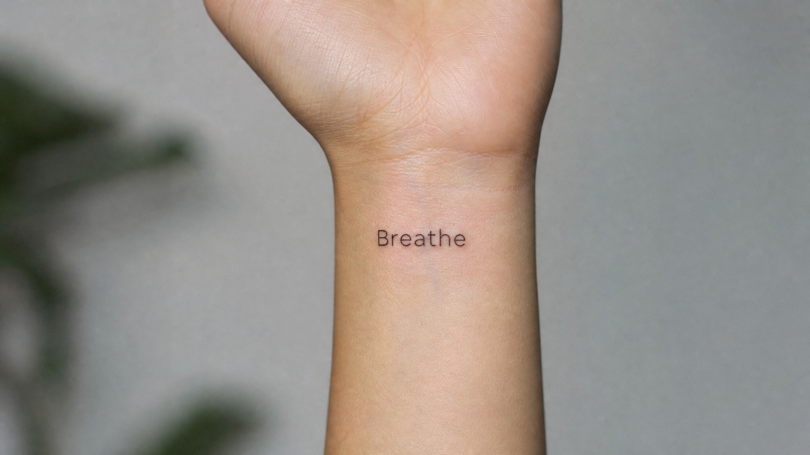 קעקוע מילה באנגלית על פרק היד, Breathe, נשום, בקו דק