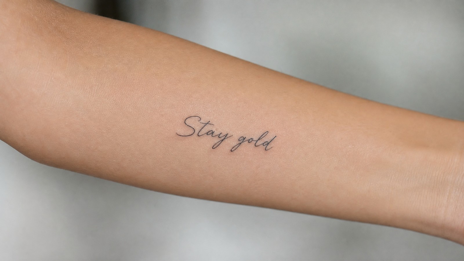 קעקוע משפט באנגלית על האמה, Stay gold, הישאר זהב, בקו דק