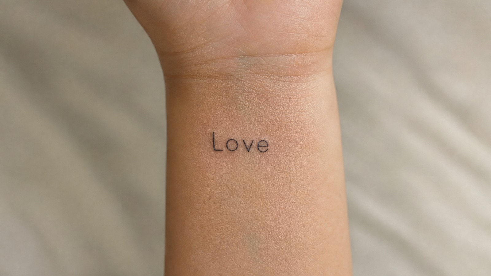 קעקוע מילה באנגלית על פרק היד, Love, אהבה, בקו דק